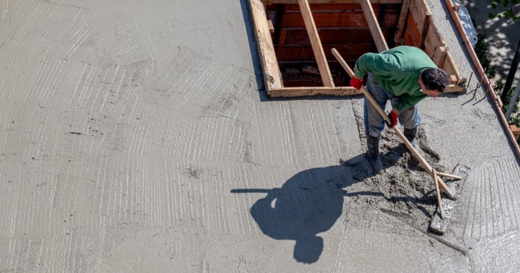 homme qui étale du béton sur toit plat