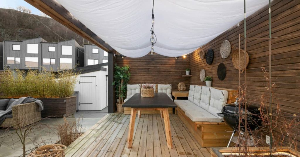 terrasse en bois avec des canapés et une table au milieu