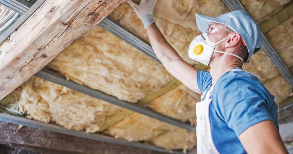 un travailleur qui inspecte une isolation de toiture