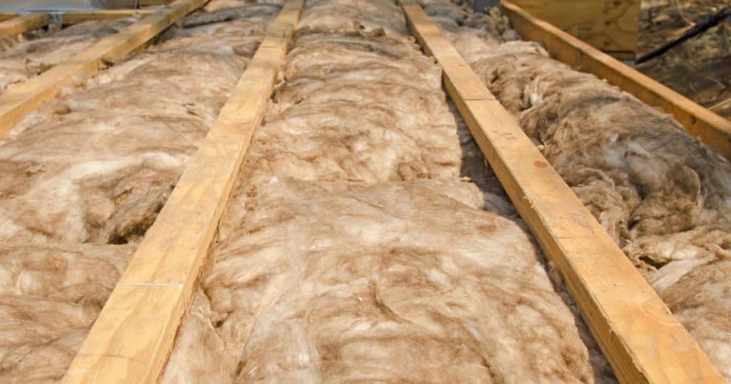Isolation thermique du plancher avec de la laine naturelle entre les poutres en bois.