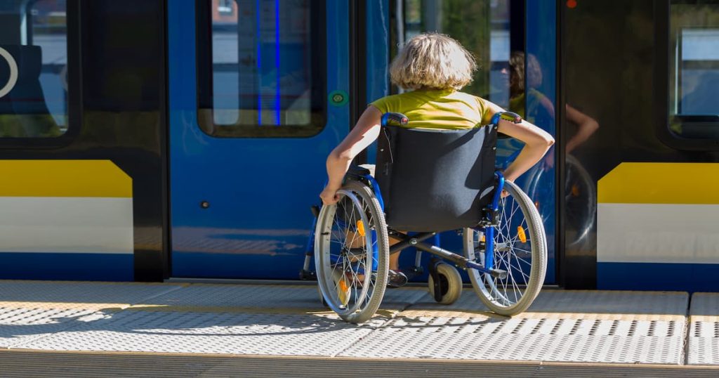 Une personne handicapée en chaise roulante qui s'apprête à prendre les transports en commun 