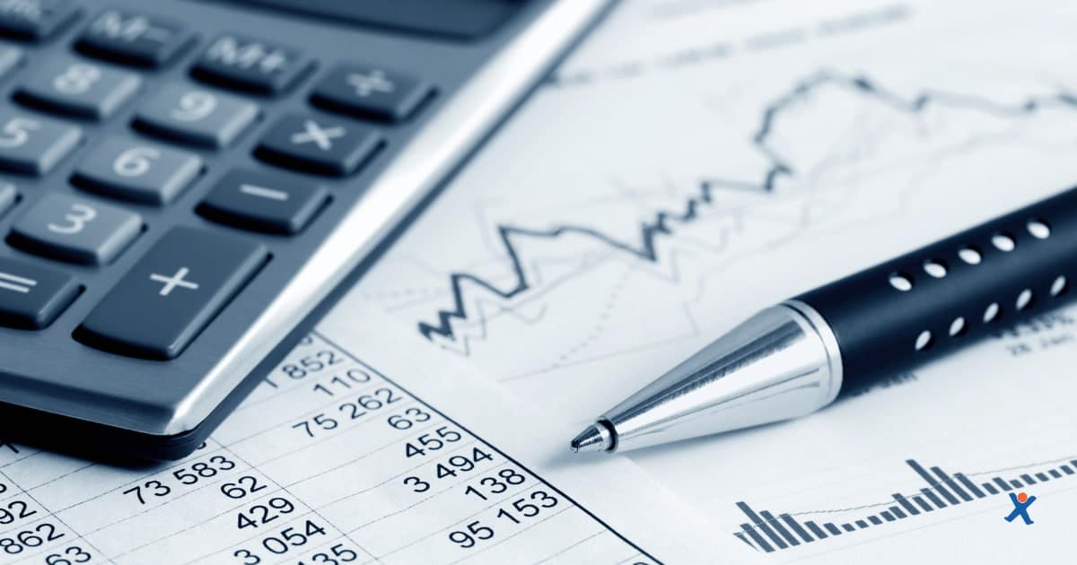Gros plan sur une calculatrice, un graphique financier et un stylo posés sur un rapport comptable, illustrant une analyse financière ou la tenue de comptabilité.