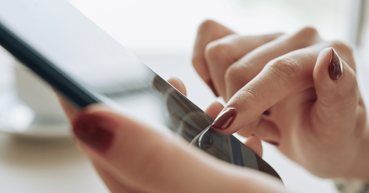 Femme utilisant l'application Pluxee sur son smartphone en touchant l’écran tactile avec ses doigts