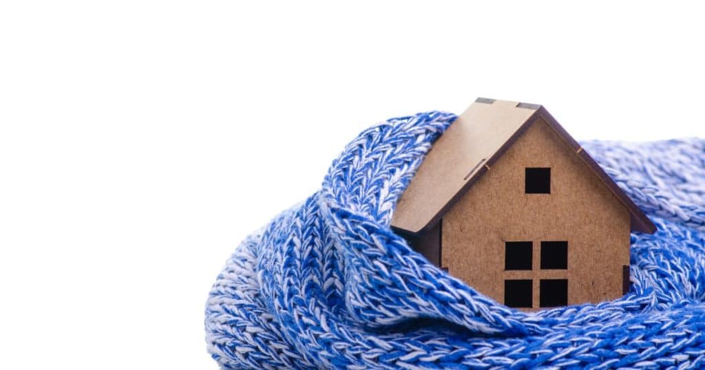 Une maison en carton entourée d'une écharpe bleue chaude