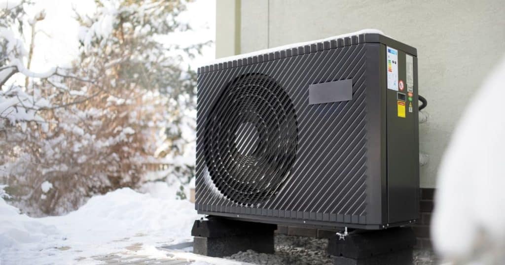 Une pompe à chaleur noir à l'éxtétieur dans la neige