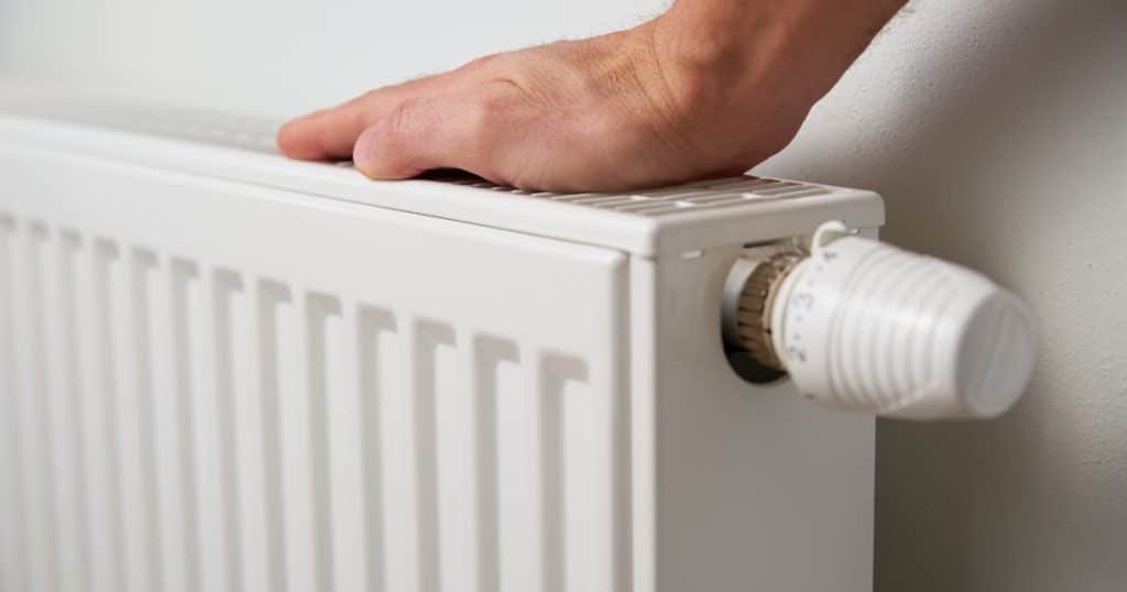 Une main posée sur un radiateur