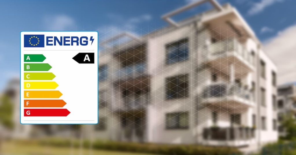 Graphique du label énergétique que l'on retrouve sur un certificat PEB de l'UE devant un immeuble d'appartements en tant que concept d'efficacité