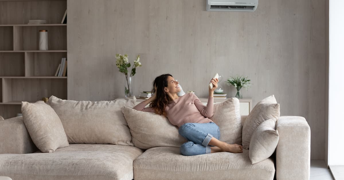 femme dans son salon avec clim juste au dessus d'elle 