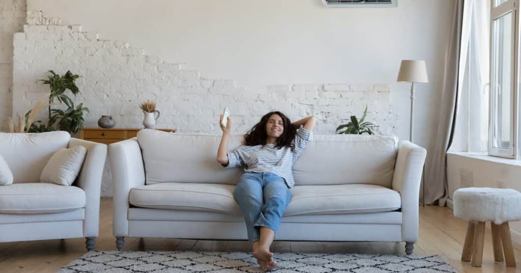 Femme en train de profiter de son air conditionné en appartement