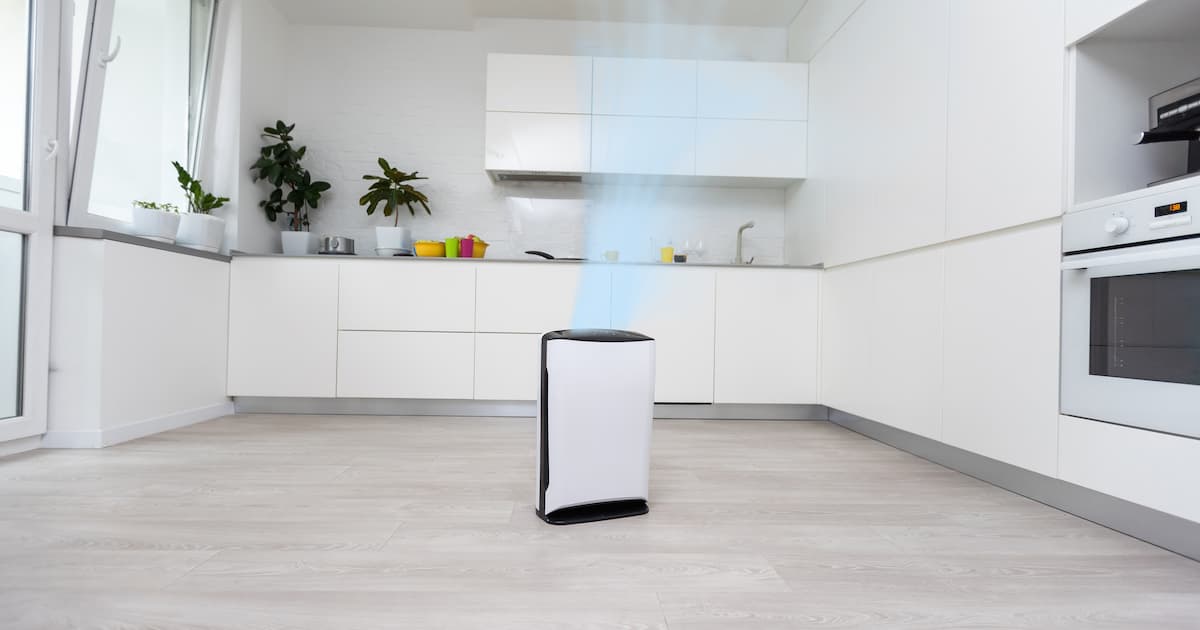 Un climatiseur mobile déshumidificateur au milieu d'une cuisine blanche 