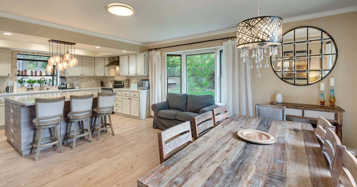 cuisine avec îlot, nombreux luminaires, chaises en lin, grande table en bois massif. Plâtre vénitien couleur blé, parquet en chêne clair.