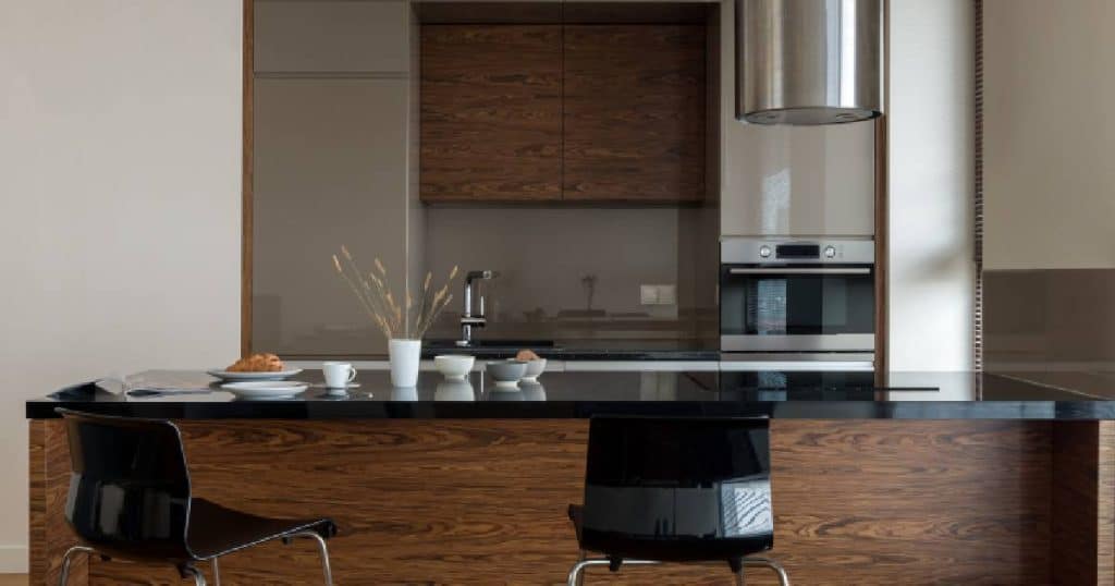 Cuisine beige avec finition bois et plan de travail en marbre noir
