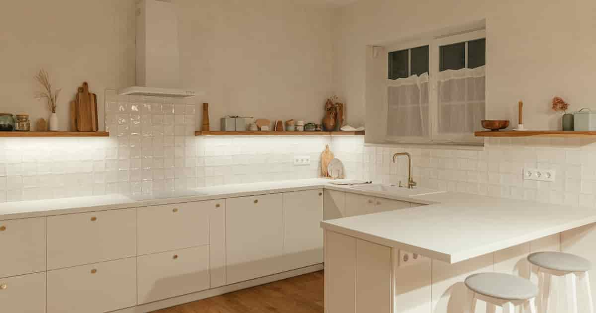 Intérieur de la cuisine en U moderne. Élégantes armoires de cuisine blanches avec poignées en laiton, îlots en granit, 
