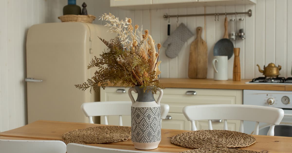 Cuisine de campagne taupe avec table en bois et vase