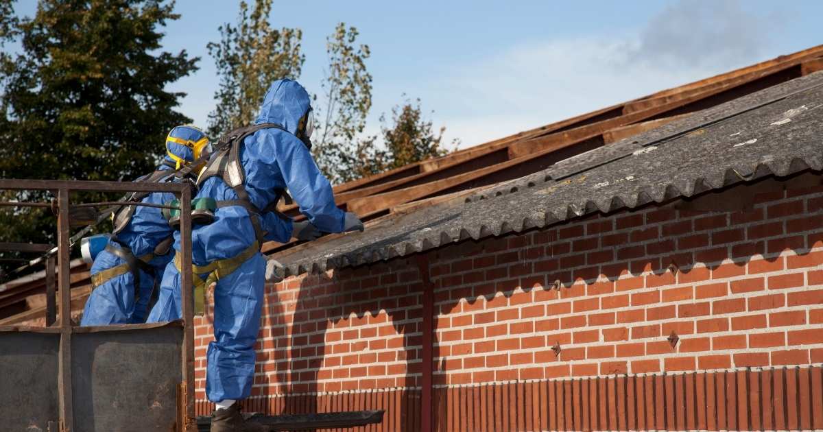 Travaux de désamiantage d'un toit par des professionnels en combinaison.