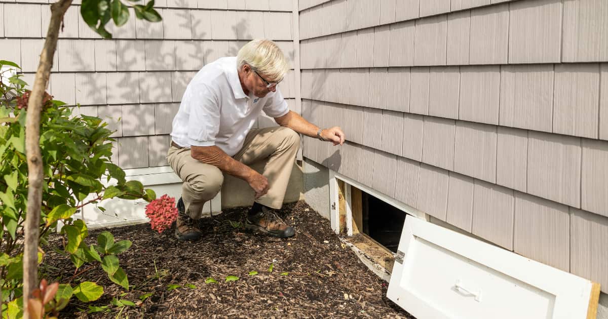 Une personne qui regarde un vide sanitaire par dehors