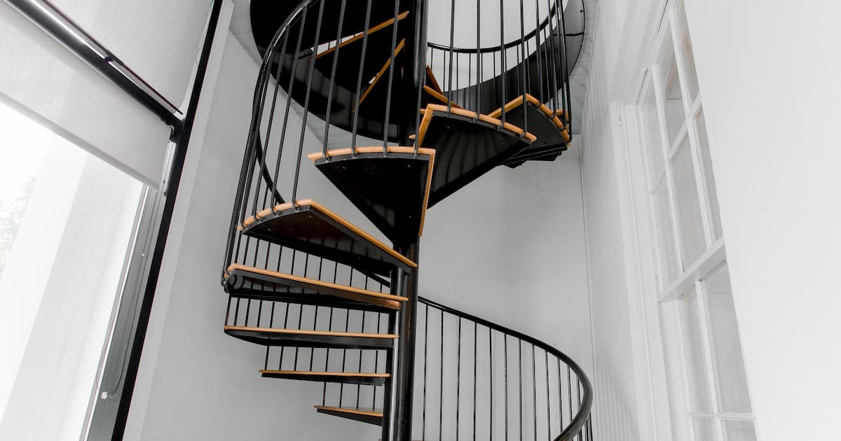 Escalier en spirale Marches modernes en bois et en noir avec intérieur blanc et éclairage de piste