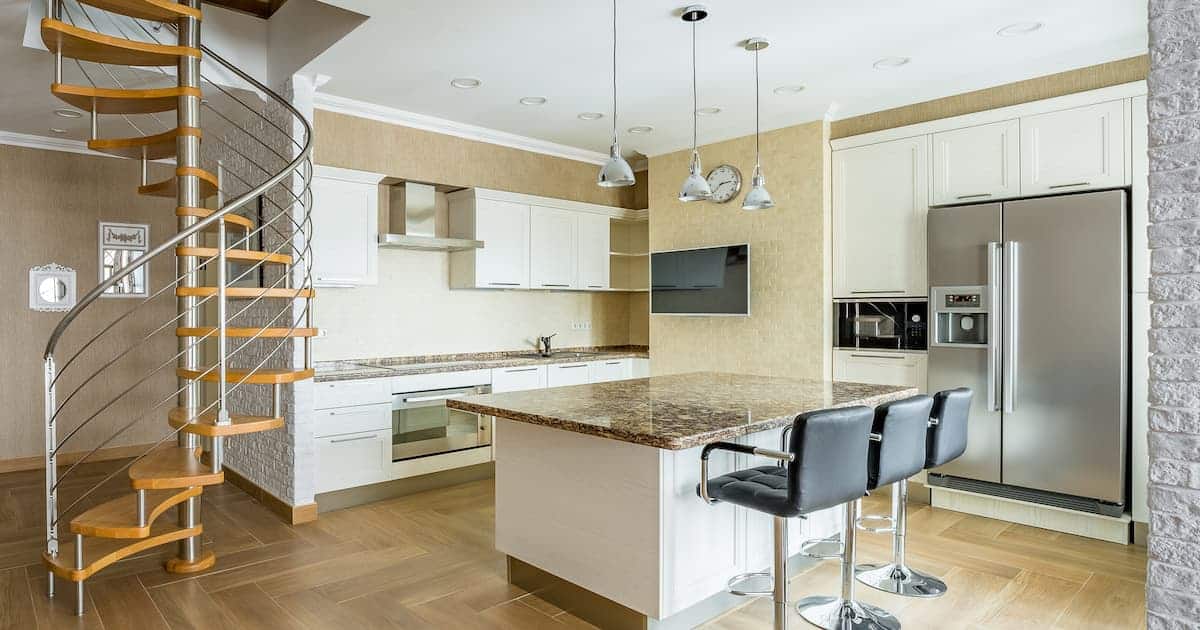 Cuisine blanche avec un escalier en colimaçon en bois