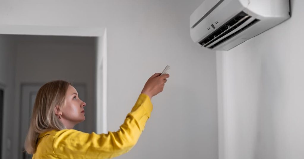 femme qui règle la clim