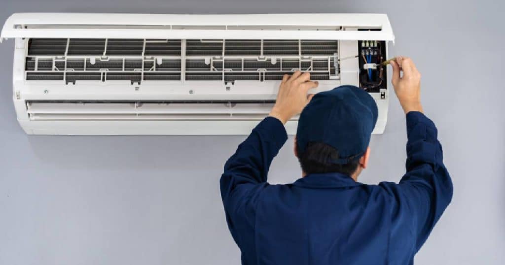Un homme en train d'installer une clim Mitsubishi