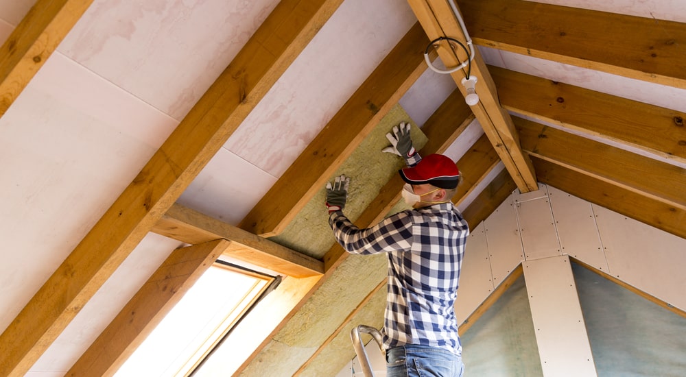 expert qui pose rouleau sur toit intérieur (combles)