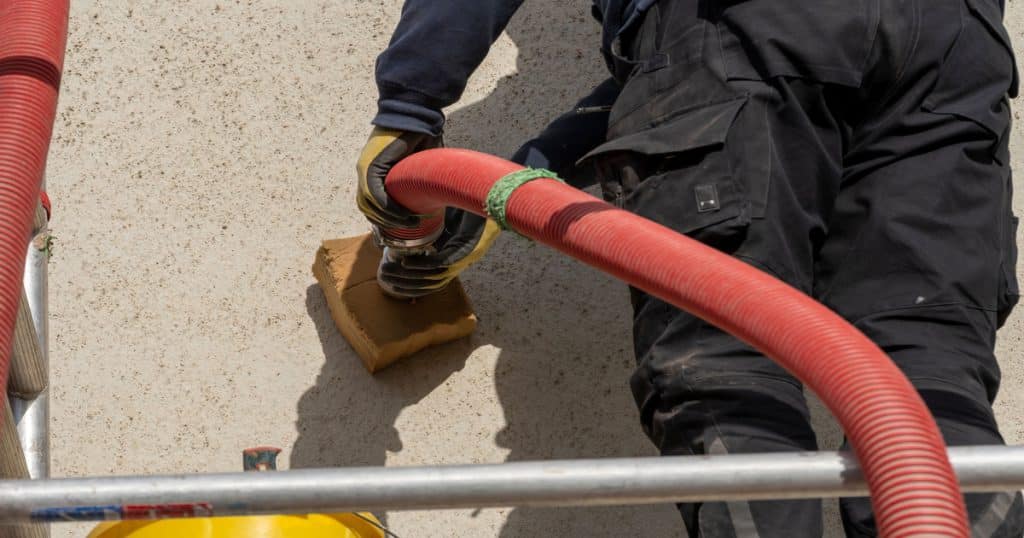 Un homme sur un échafaudage en train d'isoler un mur par injection