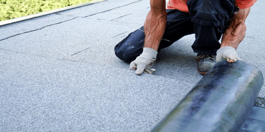 Un homme en train d'isoler une toiture plate