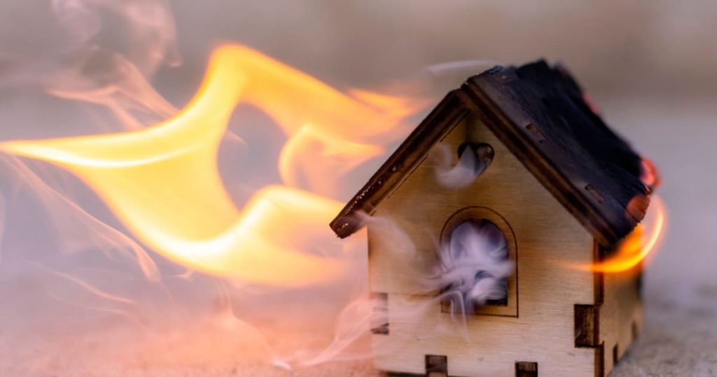 maquette de maison en bois en feu avec de la fumée