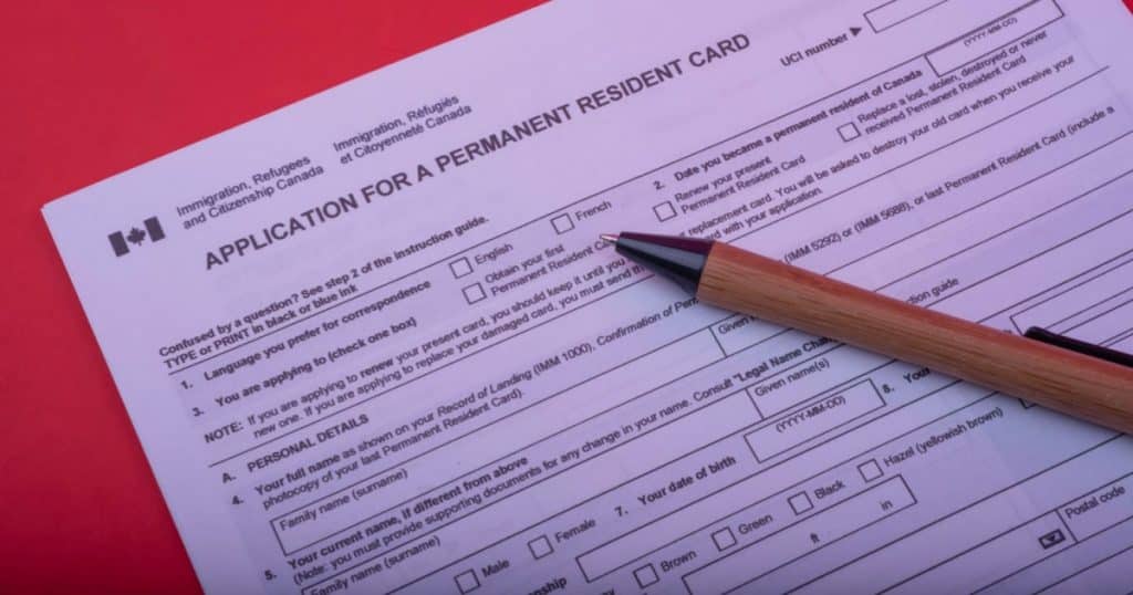 Document permettant de remplir une demande de carte de résident permanent. Un bic est posé sur la première page. 