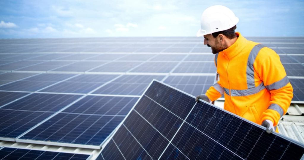 Un professionnel installant des panneaux solaires faisant partie d'une centrale solaire