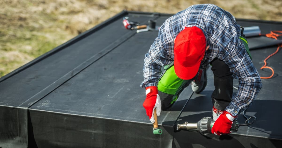Un professionnel effectuant la pose d'une toiture en EPDM