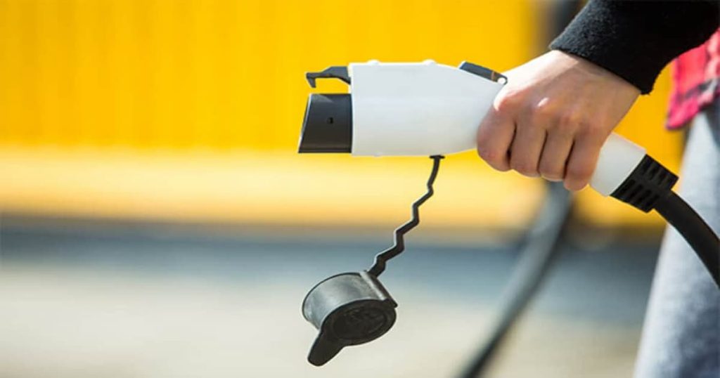 Une main tenant un câble de recharge 