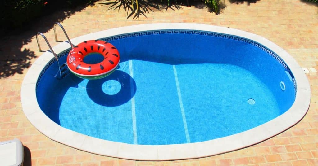 petite piscine  ronde avec une bouée rouge qui flotte
