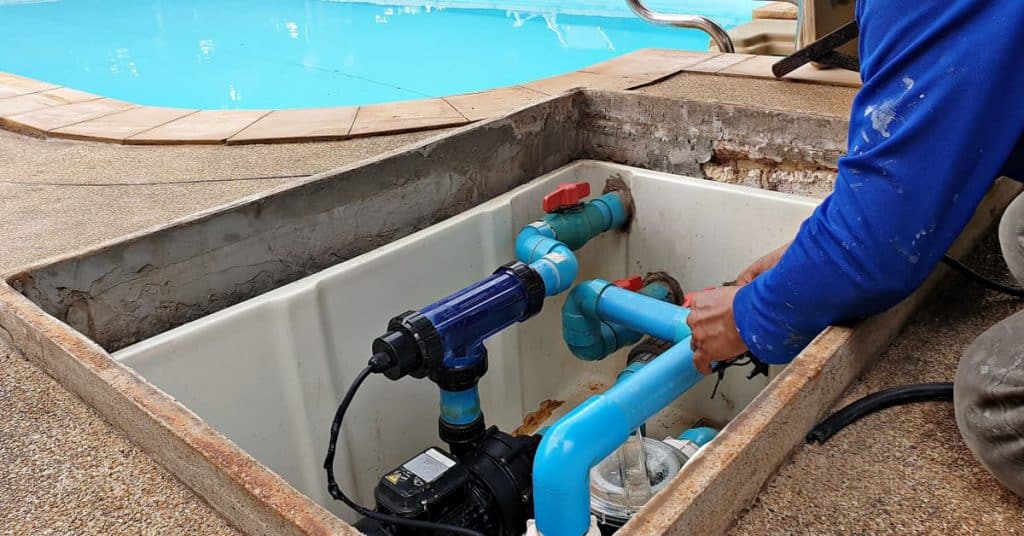 ouvrier réparant la pompe à eau de la piscine