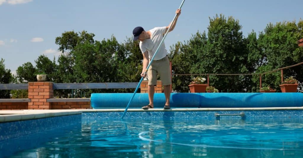 homme entrain de faire l'entretien de sa piscine