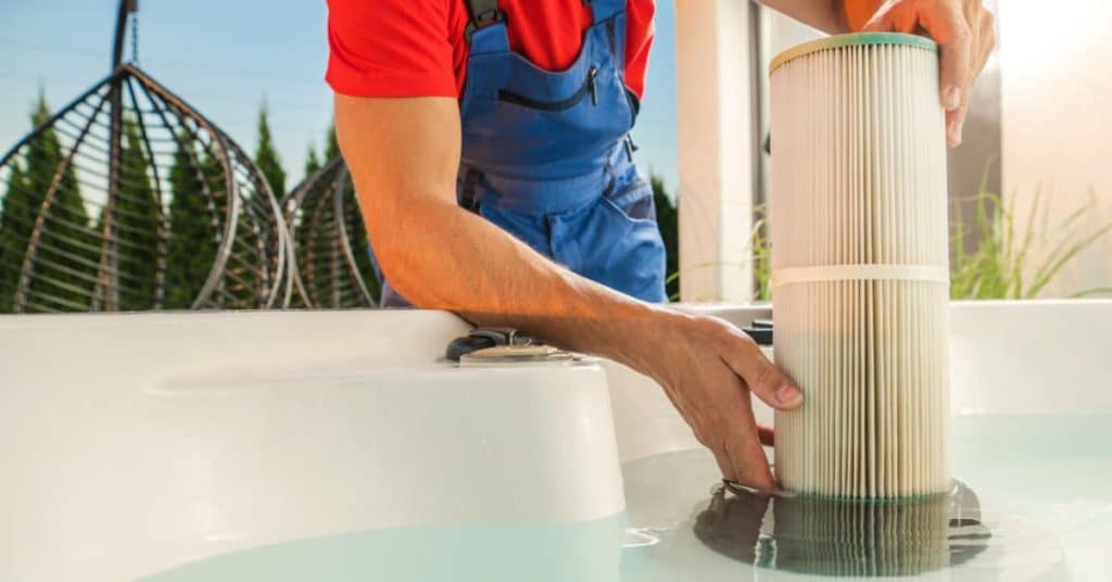technicien entretenant le filtre de piscine
