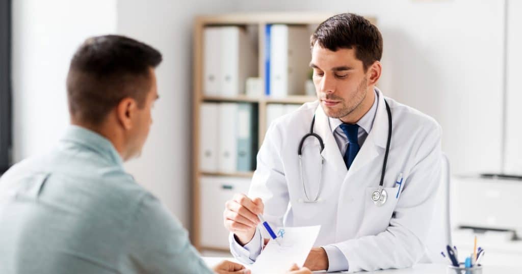 Médecin en consultation avec un patient, expliquant une ordonnance ou un traitement.
