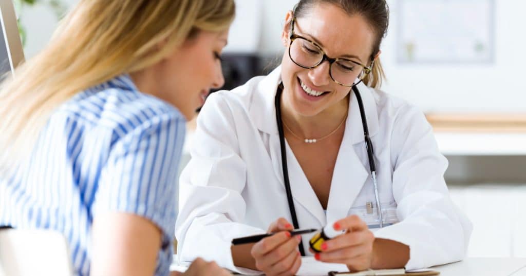 Une médecin souriante explique un traitement à sa patiente