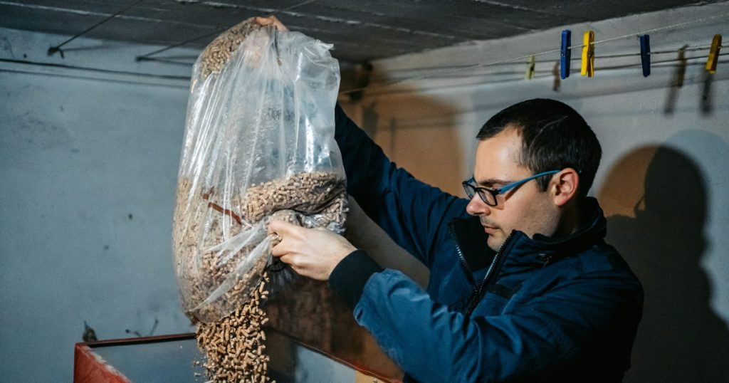 Un travailleur qui ajoute des pellets dans la chaudière