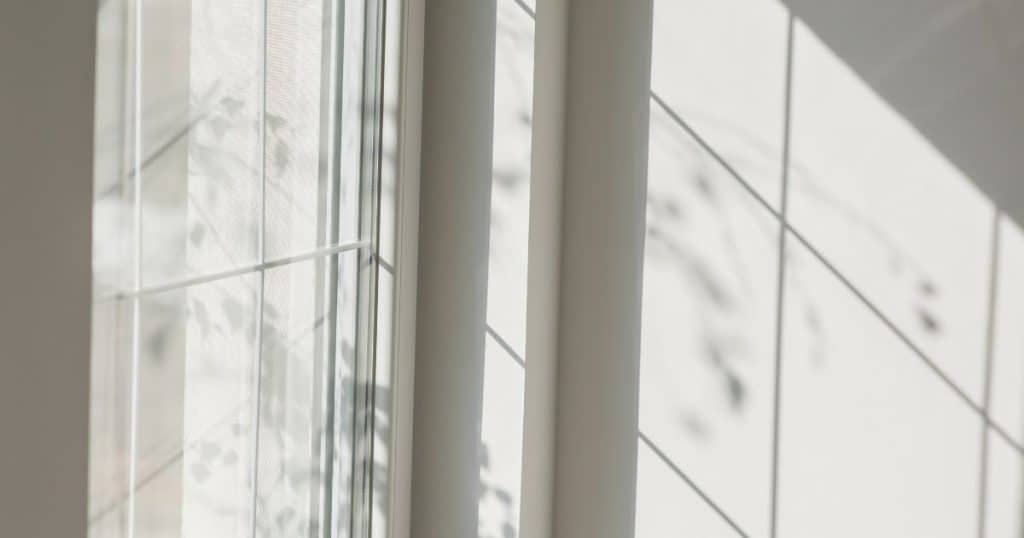 une fenêtre blanche avec son ombre sur le mur