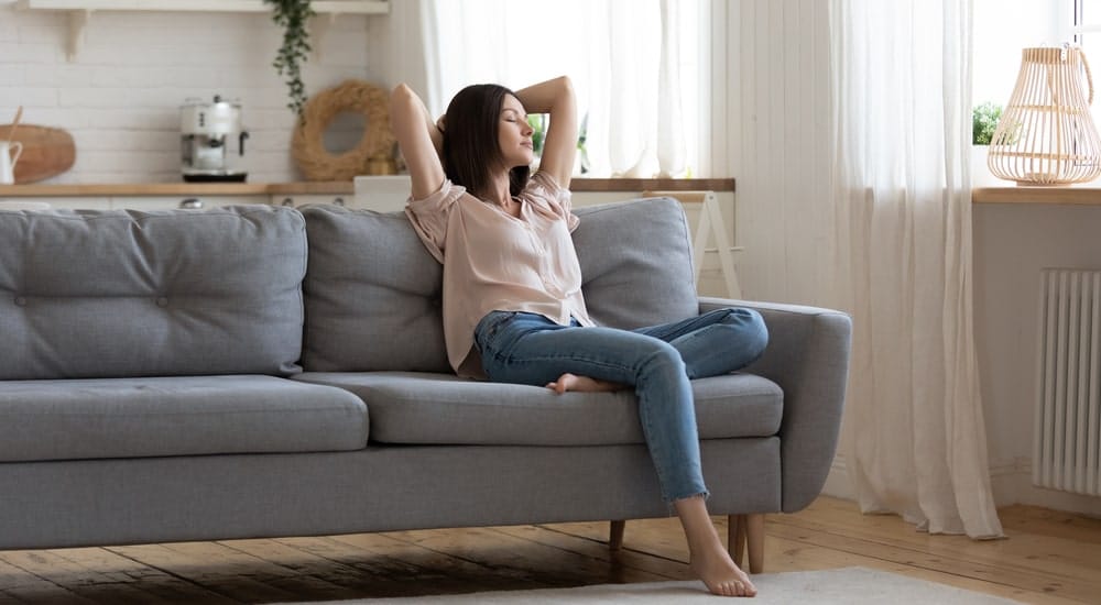 femme assise sur un canapé dans une maison saine