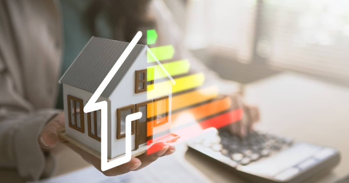 Modèle de maison tenant la main avec échelle d'évaluation de l'efficacité énergétique, représentant la maison durable, l'économie d'énergie, la réduction des coûts et la protection de l'environnement.