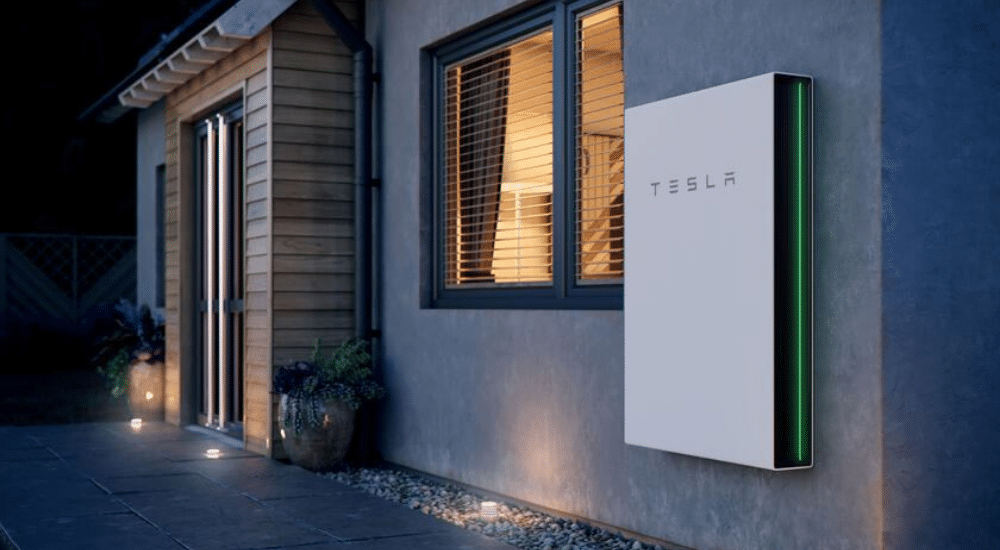 Image d'une batterie domicile tesla powerwall fixée sur le mur d'une maison.