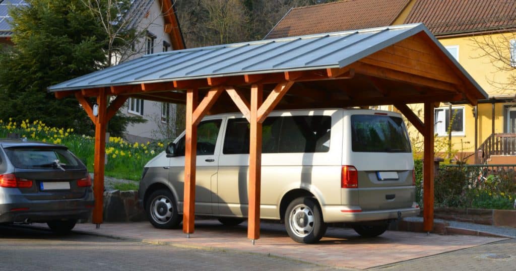 carport de voiture avec une structure en bois et une camionnette garee dessous