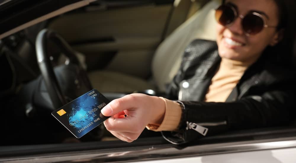 Femme utilisant sa carte carburant Esso pour faire le plein d'essence