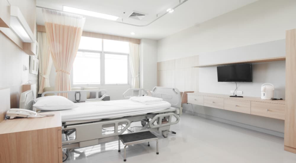 Chambre individuelle spatieuse en hôpital avec une télévision privative, un lit médical
