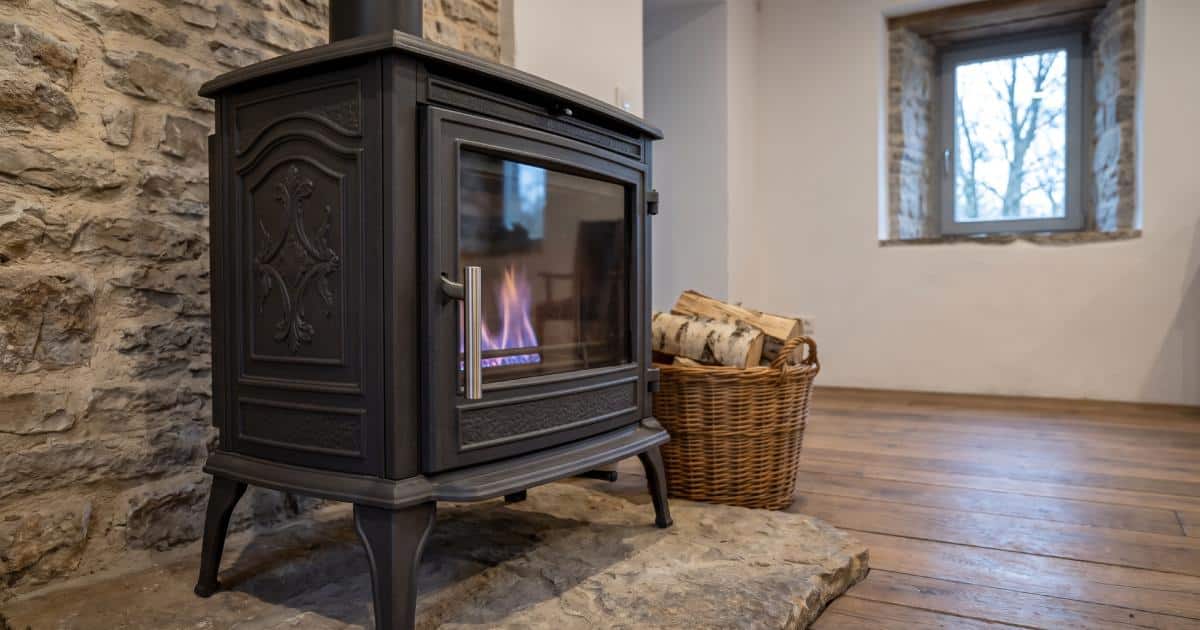 Cheminée au mazout vue de près dans le salon d'une maison avec des murs en pierre.