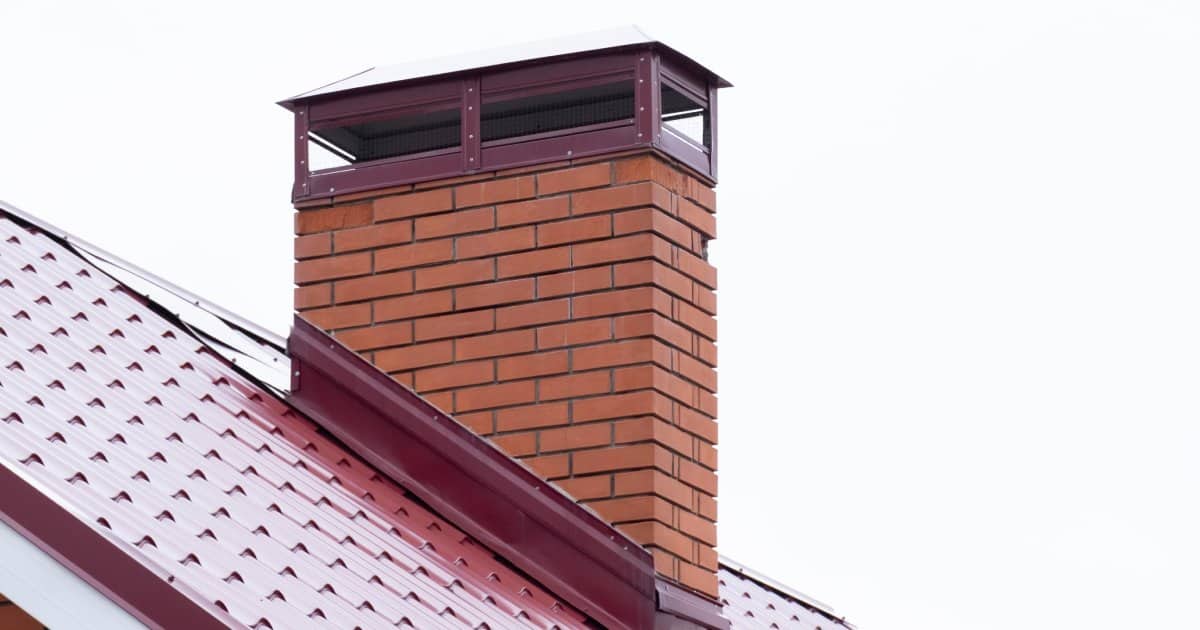 Cheminée en briques rouges sur le toit d'une habitation.