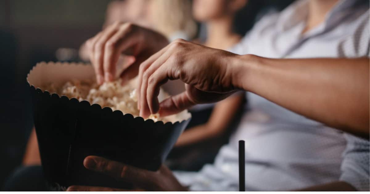 deux personnes qui mangent des pop cornes au cinéma