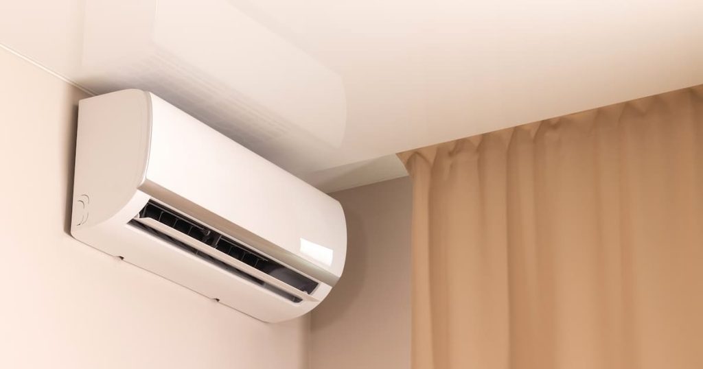 Air conditionné blanc sous plafond tendu dans une chambre moderne aux rideaux beiges
